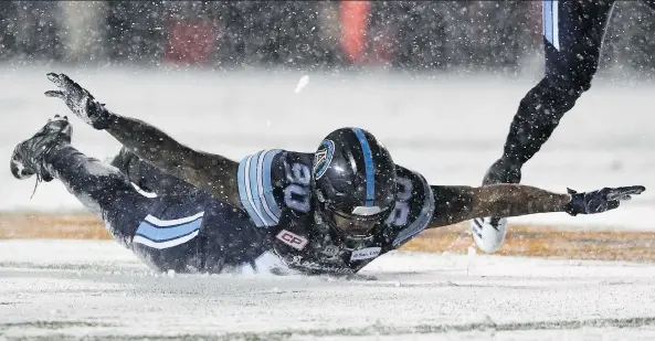  ?? PHOTOS: SEAN KILPATRICK/THE CANADIAN PRESS ?? Defensive lineman Cleyon Laing celebrates a sack in the snow in the first half. The rest of the Toronto Argonauts did the same after the win.