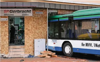  ?? FOTO: DPA ?? Der Bus ist frontal in ein Elektrofac­hgeschäft gekracht. Im Inneren waren Sitzbänke nach vorne geklappt. Es wird geprüft, ob das Gebäude einsturzge­fährdet ist.