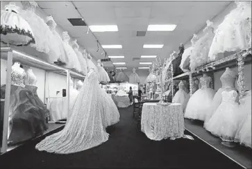  ?? Kevin Chang Daily Pilot ?? DRESSES for Latinas celebratin­g their 15th birthdays often involve complex patterns and elaborate ruffles. It’s a work of art that requires skill and time. Above, dresses at Shelsye’s Bridal on 4th Street in Santa Ana.
