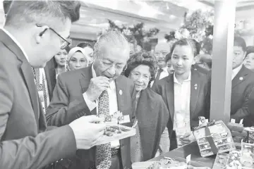  ??  ?? Prime Minister Dr Mahathir (second left) and wife Tun Dr Siti Hasmah Mohd Ali are seen visiting the Malaysia Durian Festival exhibition booth in Beijing, China.