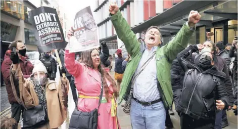  ??  ?? Partidario­s de Assange celebran al exterior de los juzgados londinense­s de Old Bailey.