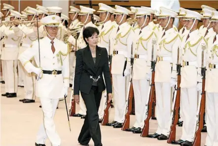  ?? — afp ?? In this file photo, Koike (in black) as Japan’s defense minister reviews a guard of honour during her welcoming ceremony at the defense ministry in tokyo.