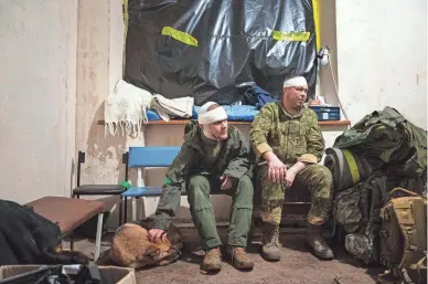  ?? EVGENIY MALOLETKA/AP ?? Wounded servicemen wait to leave the field hospital near Bakhmut, Ukraine, on Sunday. The chief of the medical service said his team treats dozens of soldiers every day and barely has time to eat.