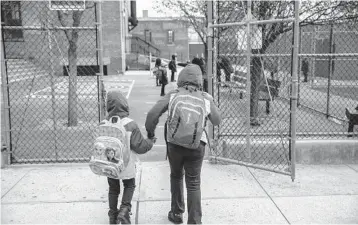  ??  ?? Getting the nation’s 3 million teachers vaccinated against COVID-19 could be a slow process because of logistics and other factors. Above, elementary school students in the Brooklyn borough of New York City.