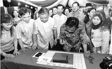  ??  ?? Abdul Karim (second right) tries his hand at Chinese calligraph­y. Looking on from right are Rogayah, United Chinese Associatio­n (UCA) Sibu president Kong Hian Khim and Hii.