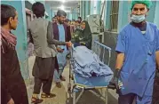  ?? (AFP) ?? People shift one of the three women media workers shot in two separate attacks, at a hospital in Jalalabad on Tuesday
