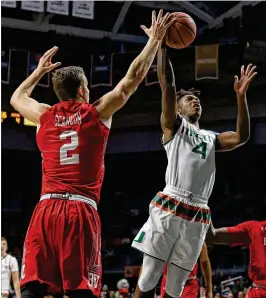  ?? DAVID SANTIAGO / MIAMI HERALD ?? Miami’s Lonnie Walker IV, driving to the basket against Boston University’s Tyler Scanlon, shot 9 for 15 with five 3-point baskets.