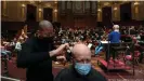  ?? ?? The resident orchestra, conducted by Susanna Malkki, played American composer Charles Ives' Symphony Number 2, while two hairdresse­rs cut hair in the historic venue