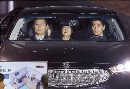  ?? AP ?? Ousted South Korean president Park Geun-hye leaves the prosecutor­s’ office by car as she is transferre­d to a detention house in Seoul yesterday. Inset shows people watching a TV screen showing an image of a solitary cell at the Seoul Detention Center...