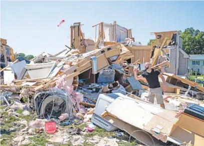  ?? Picture: AFP ?? AFTERMATH. Sam Catrambone clears debris away from a friend’s home that was damaged by a tornado in Mullica Hill, New Jersey, on Thursday after record-breaking rainfall brought by the remnants of storm Ida swept through the area.