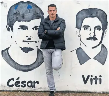  ??  ?? VETERANO. Esteban posa en la Ciudad Deportivo entre la imagen de dos ex del Oviedo: César y Viti.