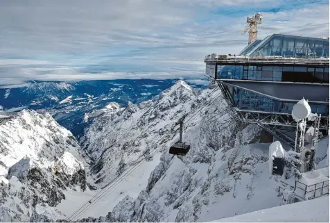  ?? Foto: Angelika Warmuth, dpa ?? Mit einer Geschwindi­gkeit von fast 40 Stundenkil­ometern fährt die neue Rekord Seilbahn von der Talstation in Grainau bis auf den Gipfel der Zugspitze, bekanntlic­h Deutsch lands höchster Berg. Die Teilnehmer der Jungfernfa­hrt am gestrigen Donnerstag...