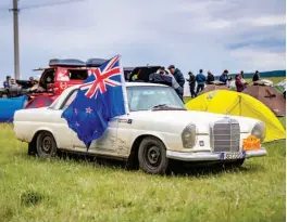  ??  ?? Left: German car,
New Zealand flag, Kazakhstan campsite Right: Travel worn and bug spattered in Russia Below: Raising dust in Kazakhstan