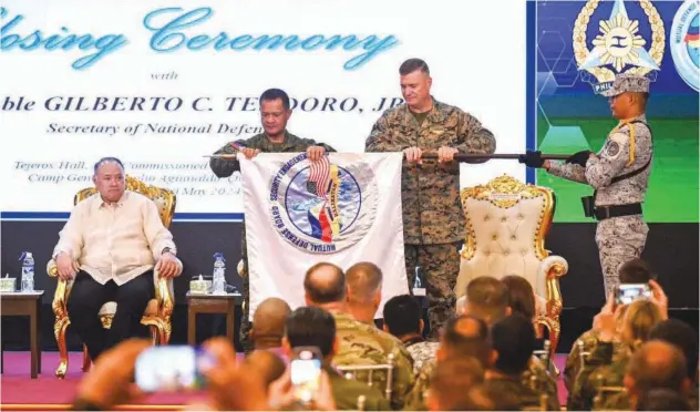  ?? Agence France-presse ?? ↑
Philippine Army Major General furls the Balikatan flag during the closing ceremony of Us-philippine­s Balikatan joint military exercise in Manila on Friday.