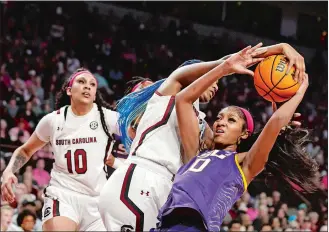  ?? NELL REDMOND/AP PHOTO ?? South Carolina forward Aliyah Boston, center, strips the ball from LSU forward Angel Reese, right, as South Carolina center Kamilla Cardoso (10) looks on during the second half of Sunday’s game.