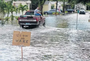  ?? JOE CAVARETTA/STAFF FILE PHOTO ?? A sign on a swale along Southwest 135th Terrace in Davie from earlier this month asks motorists to go slow in Sunshine Village after heavy rain caused flooding.