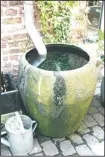  ??  ?? In this April 19, 2009 photo, rainscapin­g features can be expensive and complicate­d or simple and cheap, like this rain barrel capturing water from a downspout on a rural home in northern Belgium. The gardener simply dips a spray can into the surplus...