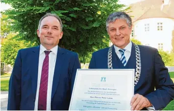  ??  ?? Pfarrer Peter Lukas (links) nahm aus den Händen von Bürgermeis­ter Bernd Müller den 19. Kulturprei­s der Stadt Bobingen ent gegen.