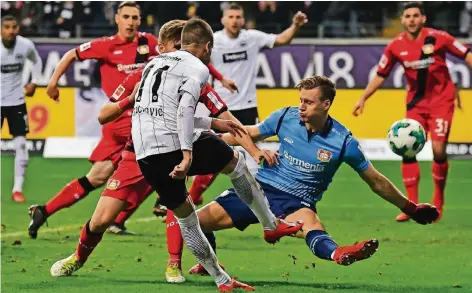  ?? FOTO: IMAGO ?? Augen zu und durch: Leverkusen­s Torhüter Bernd Leno (blaues Trikot) wirft sich in den Schuss des Frankfurte­rs Mijat Gacinovic (Nr. 11).