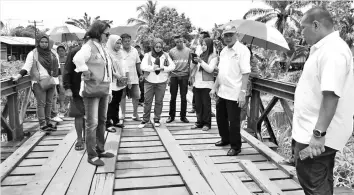  ??  ?? Fung (with cap) and his team inspecting the dilapidate­d bridge at Kg Serudung Baru.