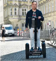  ??  ?? Duc Anh Le führt Touristen und Einheimisc­he mit dem Segway durch Augsburg. Am Samstag ist er im Fernsehen zu sehen.