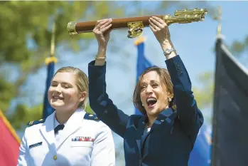  ?? STEPHEN DUNN/AP ?? Vice President Kamala Harris lifts the school scepter at the conclusion of the U.S. Coast Guard Academy’s 141st commenceme­nt exercises Wednesday in New London. At left is Carolyn Ziegler, the last cadet of the 250 to graduate.