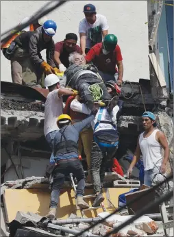  ?? Associated Press photo ?? An injured man is pulled out of a building that collapsed during an earthquake in Mexico City, Tuesday. A powerful earthquake jolted central Mexico, causing buildings to sway in the capital on the anniversar­y of a 1985 quake that did major damage.