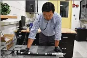  ?? SPENCER DEER / U.S. AIR FORCE ?? Dr. Vincent Chen, an Air Force Research Laboratory scientist, demonstrat­es the experiment­al setup used to trigger shape change in soft, magnetical­ly responsive elastomers.