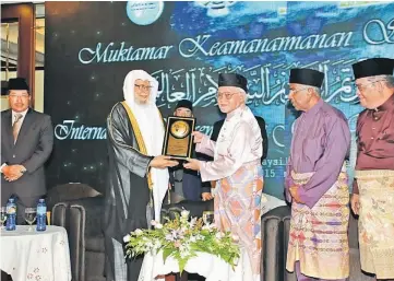  ??  ?? Abdullah presenting Taib with a memento. Looking on are Daud (second right), Putit (far right) and Misnu (far left).