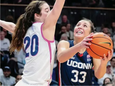  ?? Laurence Kesterson/Associated Press ?? UConn’s Caroline Ducharme (33) goes to the basket past Villanova forward Maddy Siegrist during the first half Saturday in Villanova, Pa.