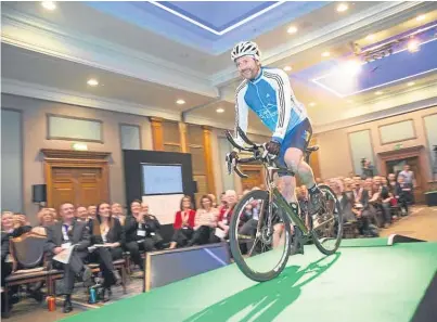  ?? Pictures: Robert Perry. ?? Entreprene­urial Scotland chairman Chris van der Kuyl takes to the stage on Mark Beaumont’s bike at the organisati­on’s annual conference at Gleneagles Hotel.