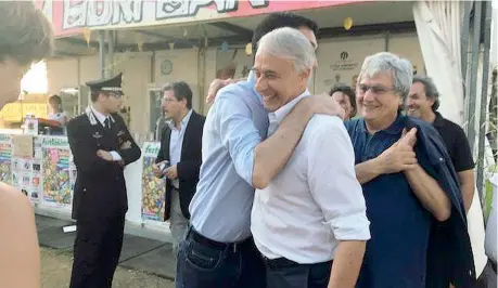  ?? (Ansa) ?? A Grosseto Il vicesegret­ario pd Maurizio Martina abbraccia Giuliano Pisapia alla festa di Legambient­e sotto gli occhi di Ermete Realacci