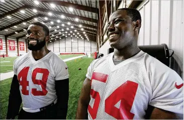  ?? PHOTOS BY CURTIS COMPTON / CCOMPTON@AJC.COM ?? Falcons rookie linebacker­s Richard Jarvis (left) from Brown University and Foyesade Oluokun from Yale University laugh after finishing team activities on Tuesday in Flowery Branch.