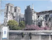  ?? FRANCOIS MORI/AP ?? Notre Dame Cathedral, seen shrouded in scaffoldin­g, is stable and secure enough for rebuilding to start.