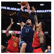  ??  ?? Jonas Valanciuna­s (centre) of Memphis Grizzlies shoots past Atlanta Hawks during their NBA game in Memphis, Tennessee, on Saturday. The Grizzlies won 118-101. — AP