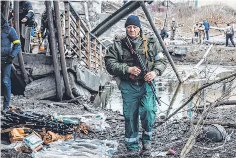  ?? FOTO: DIEGO HERRERA/DPA ?? Ein Freiwillig­er geht in Irpin an einem Haufen Waffen vorbei. Die ukrainisch­e Armee widersteht vorerst den schweren Angriffen ihrer Hauptstadt Kiew durch Russland, wo die Kämpfe immer heftiger werden.