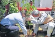  ?? HT ?? Chief minister Tirath Singh Rawat (right) planting a sapling of Rudraksha in the Uttarakhan­d House in Delhi on Saturday.