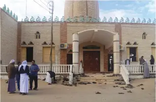  ?? (Mohamed Soliman/Reuters) ?? PEOPLE STAND outside the Al Rawdah mosque in Bir Al-Abed, Egypt this week, where a terror attack killed over 300 people.