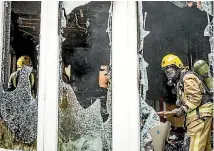  ?? BRADEN FASTIER/NELSON MAIL ?? Firefighte­rs inside the gutted house following yesterday’s early morning blaze in Seymour Ave, Nelson.