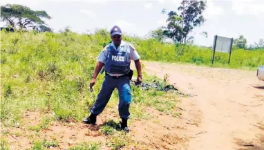  ??  ?? A Mtubatuba police officer points to where the murdered homeless man was found