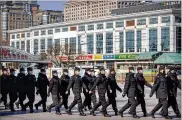  ?? MARK SCHIEFELBE­IN / AP ?? Policemen wear face masks as they march in formation outside the Beijing Railway Station in Beijing, China, on Saturday.