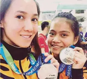  ??  ?? Leong Mun Yee (left) and Traisy
Vivian Tukiet show off their 10m platform synchro silver medals won in the Asian Diving Cup in
Macau yesterday.