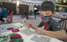  ?? Pittsburgh Post-Gazette ?? Jace Altenbaugh, 6, of Green Tree, makes Christmas cards Monday that will be placed in care bags and given to people experienci­ng homelessne­ss, at the Cove Art Center in Avalon.