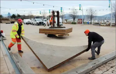  ?? RON SEYMOUR/The Daily Courier ?? City of Kelowna workers install wooden edges for the ice rink at Stuart Park on Thursday. Plans are to open the outdoor rink to skating on Nov. 30, but the firepit will not be turned on as part of the city’s efforts to reduce natural gas consumptio­n.