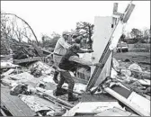  ?? JIM LYTLE/AP ?? Roman Brown, left, and Sam Crawford move debris Sunday as they search a destroyed home near Hamilton, Miss.