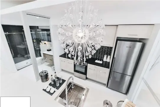  ?? PHOTOS: BENOIT DESJARDINS ?? A spectacula­r, eye-catching chandelier dominates this bird’s-eye view of a kitchen in the La Catherine project being built on Ste. Catherine St. W. near the old Forum. The 15-storey building, with more than 100 condos, is featured in this year’s Open...
