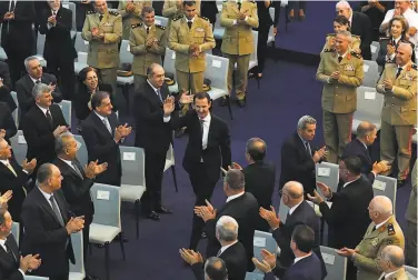  ?? Syrian Presidency ?? Syrian President Bashar Assad greets supporters upon arrival to take the oath of office in the capital of Damascus. His new term starts in a country devastated by war and facing a worsening economic crisis.