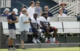  ?? MARK HUMPHREY — THE ASSOCIATED PRESS ?? Titans running backs Dion Lewis (33) and Derrick Henry (22) rest on a cooling bench during training camp Wednesday in Nashville, Tenn. The Titans put a bench on each side of their three practice fields, giving players a chance to recover when the temperatur­e during morning practices can feel like 90 degrees.