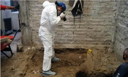 ?? Public Prosecutor's/AFP/Getty Images ?? A forensic worker takes a picture at the house of the alleged serial killer in Atizapán de Zaragoza, Mexico state. Photograph: Mexico State