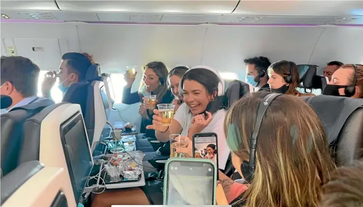  ?? BROOK SABIN/STUFF ?? The bubbles started early for passengers on Flight NZ246 from Sydney to Wellington, though many had heartbreak­ing reasons for being on board.